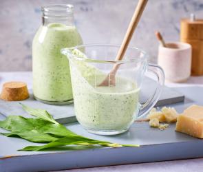 Bärlauchdressing in einem Glasgefäß mit Holzlöffel.