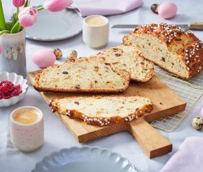 Osterbrot auf einem gedeckten Tisch mit Tulpen.
