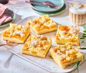 Aprikosenkuchen mit Streuseln vom Blech in Stücke geschnitten.