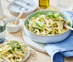 Zitronenpasta mit frischen Kräutern in einem tiefen Teller.
