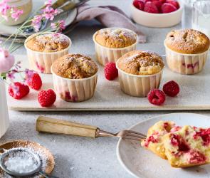 Einfache Himbeer Muffins mit frischen Himbeeren drum herum.