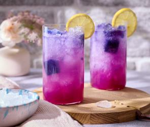 Butterfly Pea Tee Slush - pinkes Getränk in Gläsern mit Zitronenscheiben.