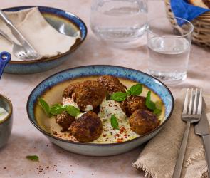 Lamm Frikadellen auf Minzjoghurt in einer bunten Schüssel.