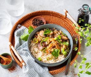 Asiatisches Pilzpfannengericht in einer Schüssel mit Essstäbchen.