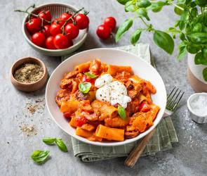 Cremige Pasta mit Chorizo und frischen Kirschtomaten in einem tiefen Teller.