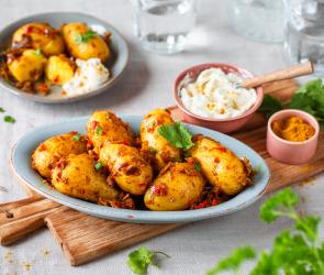 Fruchtige Bombay-Kartoffeln mit Gewürzen in Schüsseln.