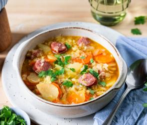 Spitzkohleintopf mit Wurst in einem tiefen Teller.