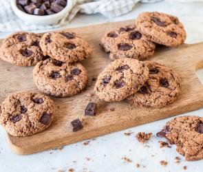 Vegane Chocolate Chip Cookies auf einem Holzbrett.