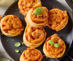 Vegane Pizzaschnecken mit Basilikum garniert.