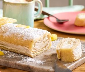 Vegane Zitronenrolle auf einer Kaffeetafel, abgeschnitten.