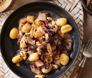 Gnocchi mit Birne und Gorgonzola in dunklen Tellern.