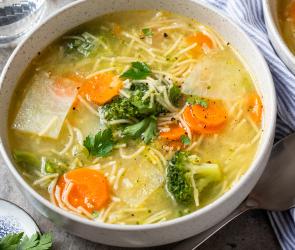 Frühlingssuppe mit buntem Gemüse in Schüsseln.
