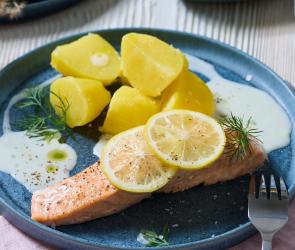 Gedämpfter Lachs mit Zitronensauce auf Tellern.