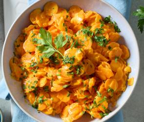 Cremiges Karottengemüse in einer Schüssel mit Petersilie.