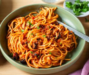 Pasta alla puttanesca mit Spaghetti in tiefen Tellern.