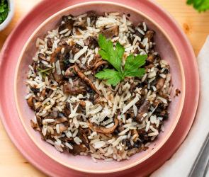 Champignons mit Reis in einer rosa Schüssel.