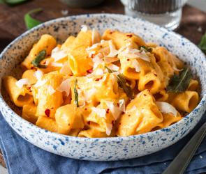 Salbei-Butternut-Rigatoni mit Ricotta in einem tiefen Teller.