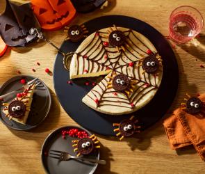 Spinnennetz No-Bake-Cheesecake auf einem gedeckten Halloween-Tisch