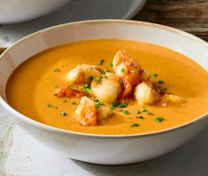 Französische Krustentiersuppe in Suppentellern.