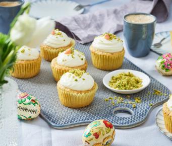 Carrot Cake Cupcakes mit Schmandcreme und Pistazien getoppt.