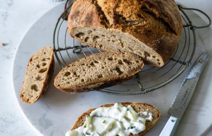 Angeschnittenes Roggen-Dinkel-Brot mit Frischkäse-Aufstrich.