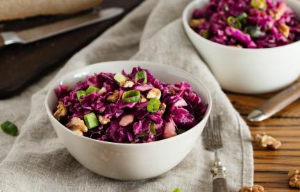 Zwei Schalen mit Rotkohlsalat auf Holztisch.