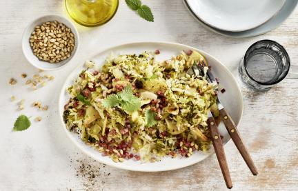 Salat mit Wirsing und Speck auf einem Teller.