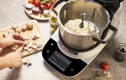 Cookit auf dem Tisch mit frisch geknetetem Teig im Topf. 