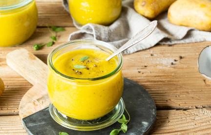 Cremige Kartoffelsuppe in Gläsern mit Kräutern garniert.