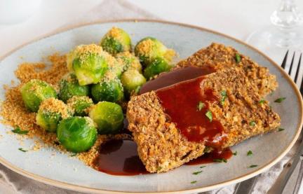 Nussbraten in Sauce mit Rosenkohl festlich arrangiert auf einem weißen Teller