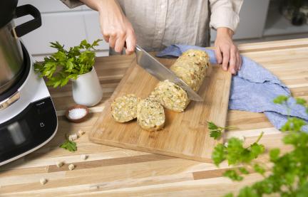 Semmelknödel wird in Scheiben geschnitten.