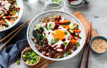 Bibimbap mit Spiegelei und Frühlingszwiebeln getoppt.