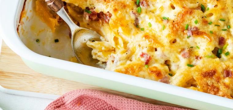 Cremiges Nudel-Schinken-Gratin auf Teller und in Auflaufform Cremiges Nudel-Schinken-Gratin auf Teller und in Auflaufform