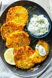 Gemüse-Kartoffel-Puffer mit Kräuterdip auf einem Teller.