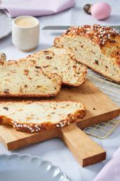 Osterbrot auf einem gedeckten Tisch mit Tulpen.