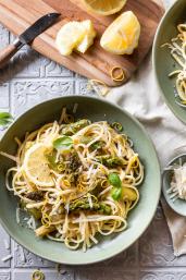 Spaghetti mit Zitronen und grünem Spargel in zwei tiefen Tellern.