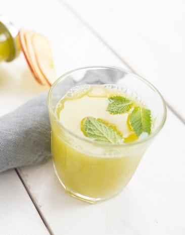 Apfel-Sellerie-Shot in einem Glas und einer Flasche.