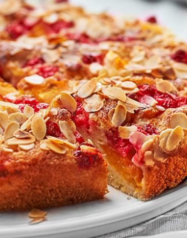 Angeschnittener Kuchen mit Mandeltopping auf Kuchentablett