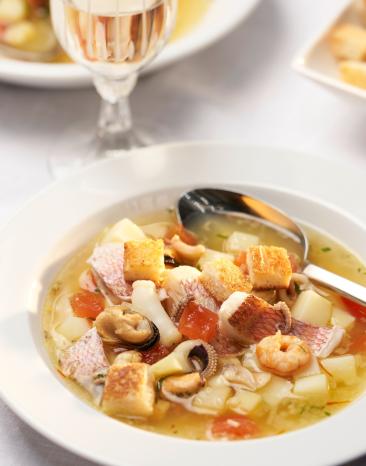 Bouillabaisse mit Croûtons in einem Teller angerichtet.