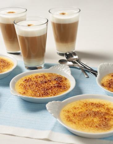 Crème brûlée in mehreren Schalen mit Kaffee auf einem Tisch.