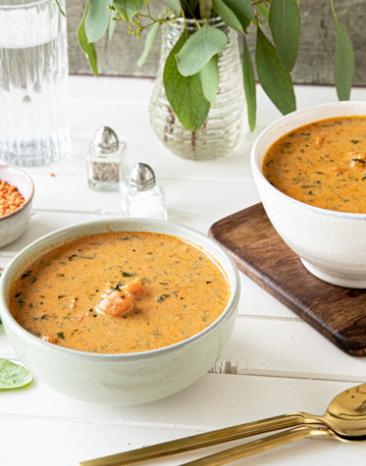 Orangene Curry-Suppe mit Süßkartoffel in zwei Schälchen Orangene Curry-Suppe mit Süßkartoffel in zwei Schälchen