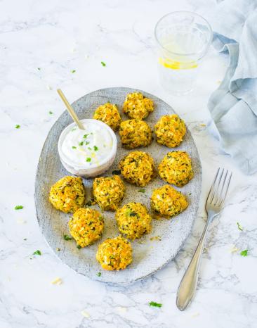 Elf Gemüsebällchen auf Teller mit Joghurt-Dip.