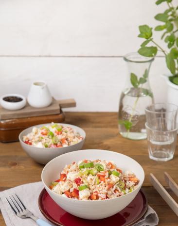 Zwei Teller mit griechischem Dinkel-Reis-Salat auf gedecktem Tisch.