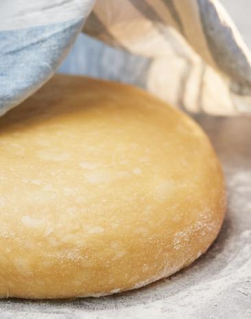 Hefeteig süß wird mit einem Tuch abgedeckt.