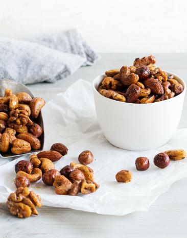 Honig-Senf-Nüsse in einem Glas und auf einem Brett.