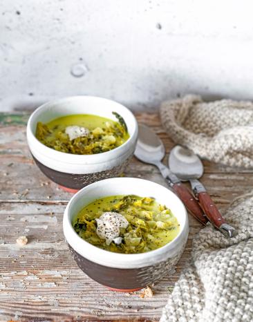Käse-Wirsing-Suppe in zwei Schalen auf einem Tisch.