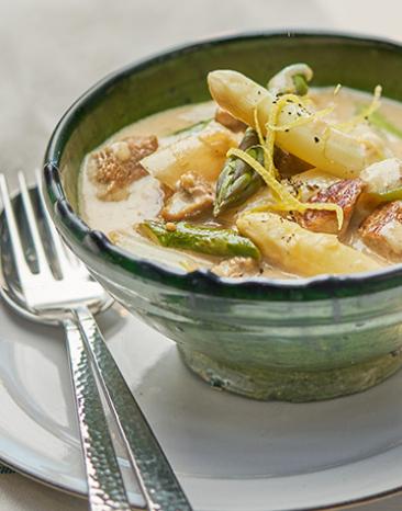 Kalbsrahmgulasch mit Spargel weiß und grün in einer Schale angerichtet.