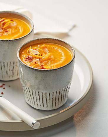 Suppe in Tasse mit Ingwer- und Chilihaube