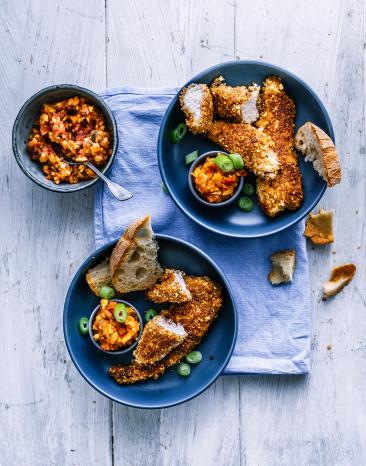 Knusper Hähnchen mit Mango-Salsa in zwei Tellern.