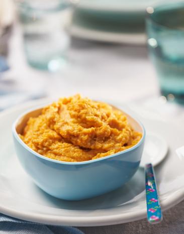 Kürbis-Risotto mit Kalbfleisch in einer Schale angerichtet.